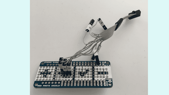 A MKR Proto Shield and 6 2.54mm straight male headers used to access the exposed pads of the board.